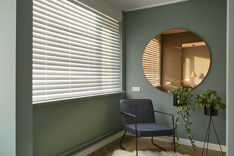 Zwarte plisségordijnen in woonkamer met mintgroene muur