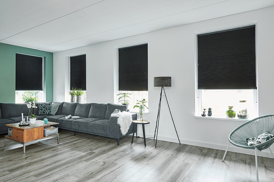 Witte jaloezieën bij olijfgroene muur